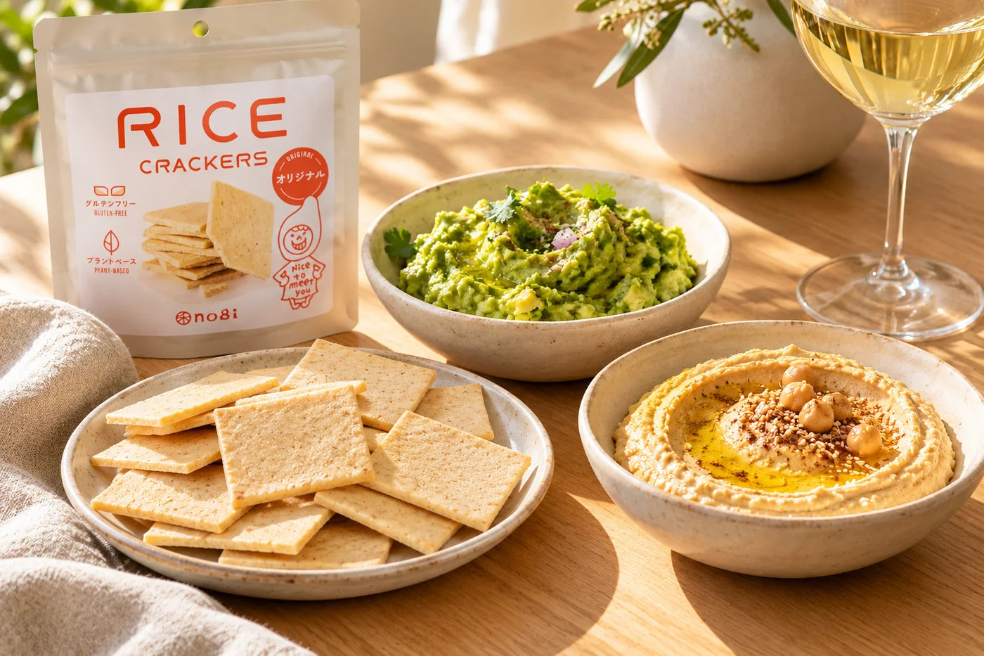 Rice crackers served with hummus, guacamole and a glass of wine